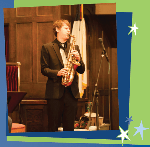 Caleb plays his sax in performance.